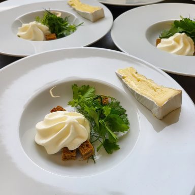 Mousse de munster et morceau de brie sur une salade d'herbe